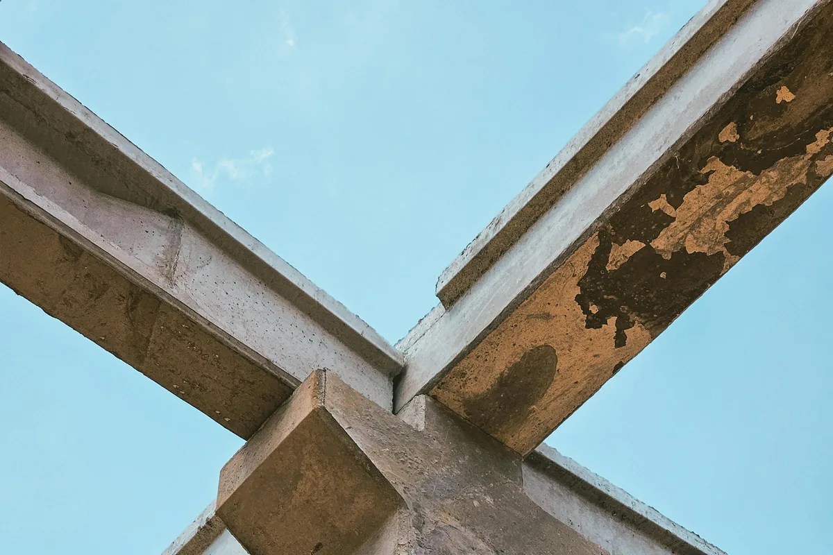 Détail d'un nœud de structure en béton apparent sous lumière chaude